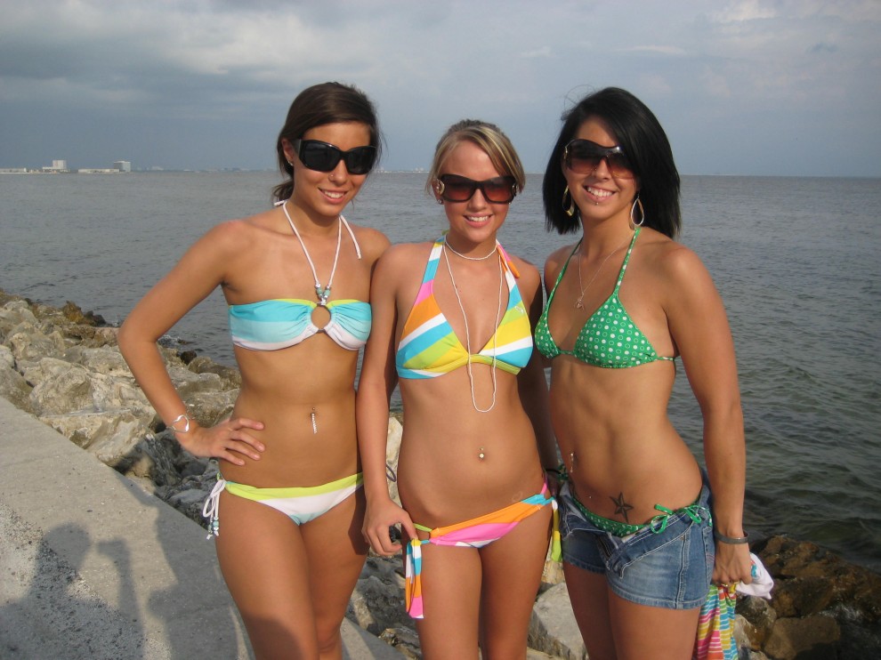 Trzy młode dziewczyny rozbierają się na plaży