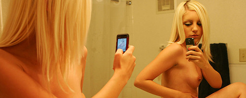 Młoda blondynka robi sobie zdjęcia w łazience