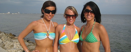 Trzy młode dziewczyny rozbierają się na plaży